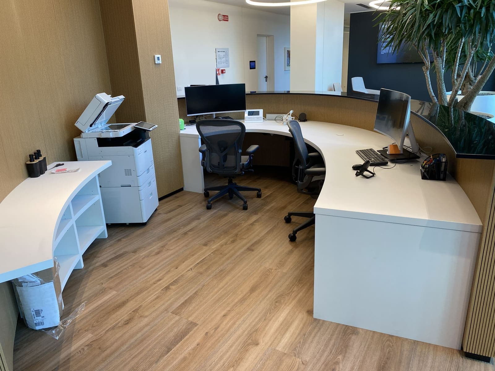 Reception curva in Corian e legno dogato — 2